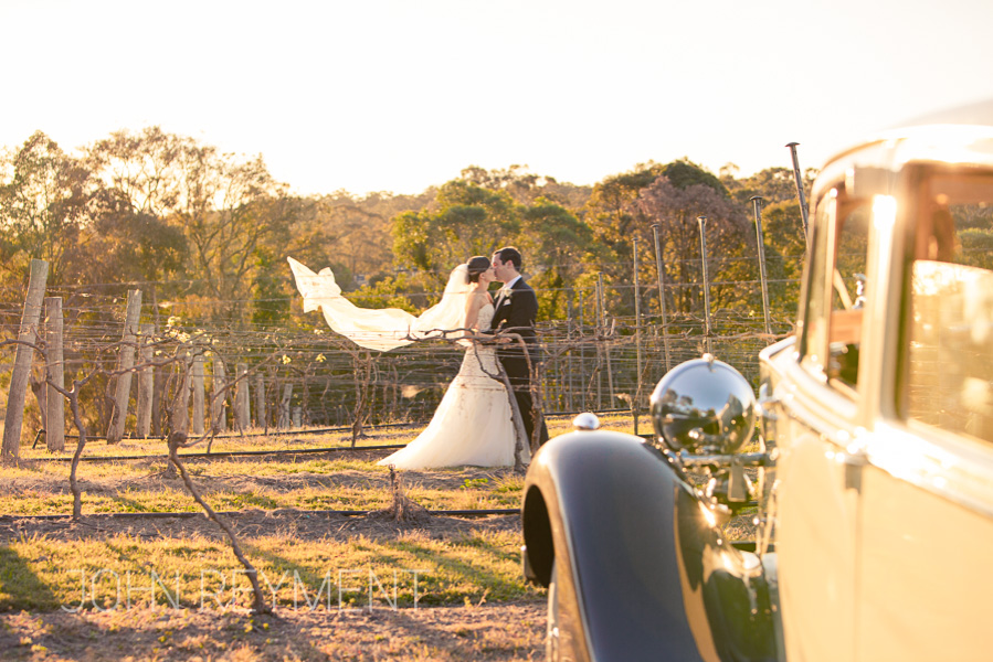 bride and groom with wedding car at Sirromet Winery by Brisbane wedding photographer John Reyment